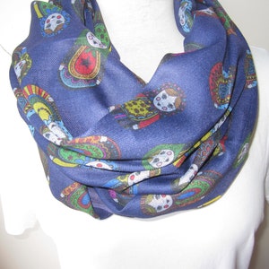May include: A navy blue infinity scarf with a colorful pattern of Russian nesting dolls.