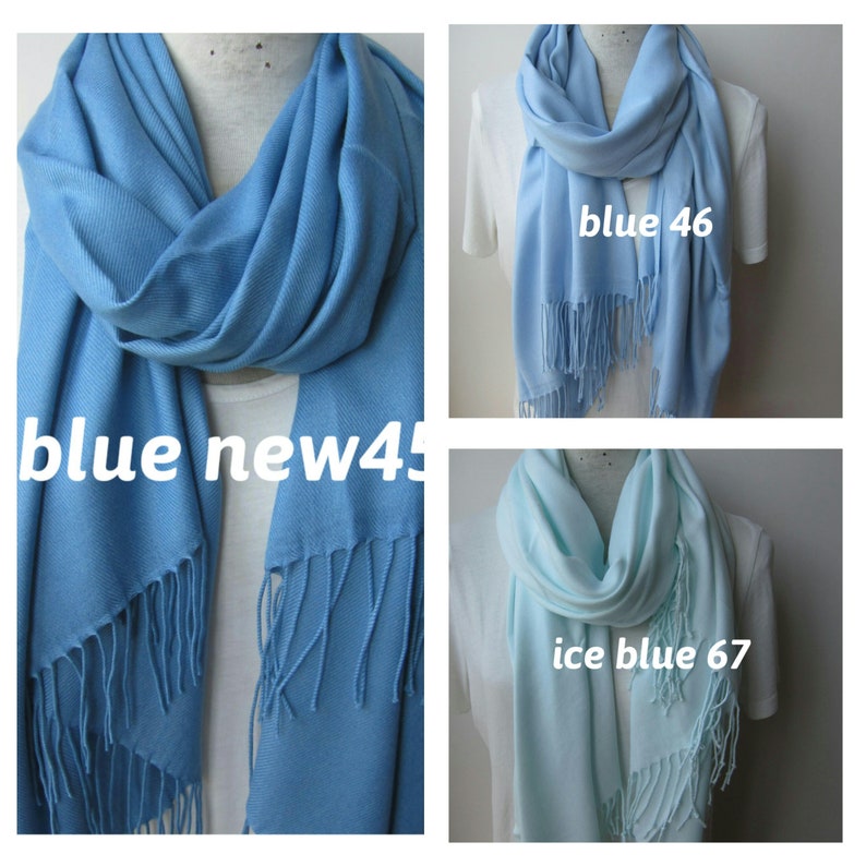 May include: Three different colored scarves, one blue, one light blue, and one ice blue. Each scarf has a fringe on the bottom.