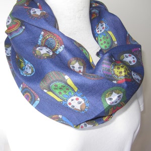 May include: A navy blue infinity scarf with a colorful pattern of Russian nesting dolls.