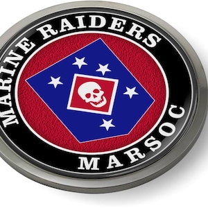 May include: A round, silver-colored Marine Raiders MARSOC emblem. The emblem features a red textured background, a blue diamond with white stars, and a skull within a red square. The words "MARINE RAIDERS MARSOC" are in white around the edge.