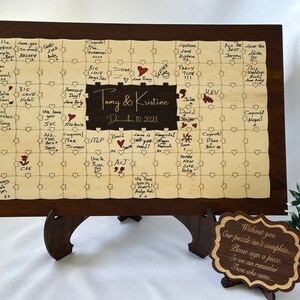 A photo of a personalized wooden wedding guest book puzzle
Custom wooden wedding guest book with customizable names and date. Features Walnut wood-colored frame ( Rectangle) and middle ( Rectangle ) section. Puzzle pieces designed with natural color.