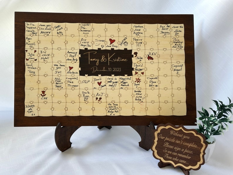 A photo of a personalized wooden wedding guest book puzzle
Custom wooden wedding guest book with customizable names and date. Features Walnut wood-colored frame ( Rectangle) and middle ( Rectangle ) section. Puzzle pieces designed with natural color.