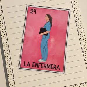 Puede incluir: Una tarjeta rosa y blanca con un dibujo de una mujer con uniforme azul sosteniendo un portapapeles negro. La tarjeta tiene el n&uacute;mero "24" en la esquina superior izquierda y el texto "LA ENFERMERA" en la parte inferior.
