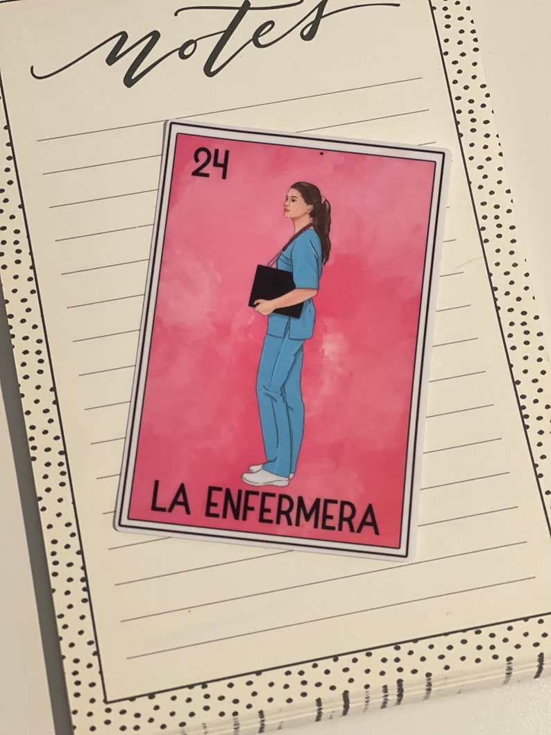Puede incluir: Una tarjeta rosa y blanca con un dibujo de una mujer con uniforme azul sosteniendo un portapapeles negro. La tarjeta tiene el n&uacute;mero "24" en la esquina superior izquierda y el texto "LA ENFERMERA" en la parte inferior.
