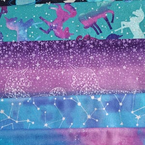 May include: A collection of colorful fabric swatches featuring celestial and fantasy themes. Designs include planets, constellations, unicorns, and starry backgrounds in shades of blue, purple, and teal. Ideal for crafting projects.