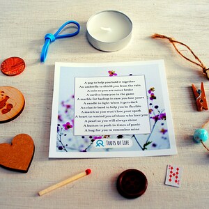 May include: A small gift box with a variety of items, including a wooden heart, a panda bear, a small candle, a match, a peg, a coin, a card, a marble, a clothespin, a pearl, beads, and a small card with a poem about the items. The poem reads: "A peg to help you hold it together, An umbrella to shield you from the rain, A coin so you are never broke, A card to keep you in the game, A marble for backup in case you lose yours, A candle to light when it gets dark, An elastic band to help you be flexible, A match so you won't lose your spark, A heart to remind you of those who love you, A pearl so you will always shine, A button to push in times of panic, A hug for you to remember mine." The card also has the text "TROTS OF LIFE" on it.