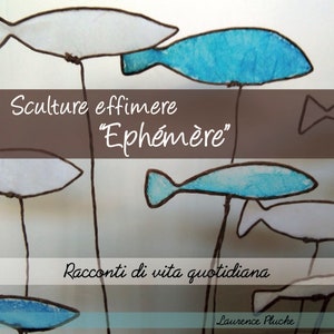May include: A collection of delicate, wire sculptures of fish, painted in shades of blue and white. The sculptures are suspended from the ceiling, creating a whimsical and airy display. The text "Sculture effimere "Eph&eacute;m&egrave;re" Racconti di vita quotidiana Laurence Pluche" is visible in the image.