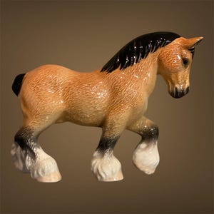 Puede incluir: Figura de caballo de cerámica en posición de caminar. El caballo tiene un cuerpo marrón, crin y cola negras, y cascos blancos y negros. La figura está detallada con pelaje texturizado y un acabado brillante.