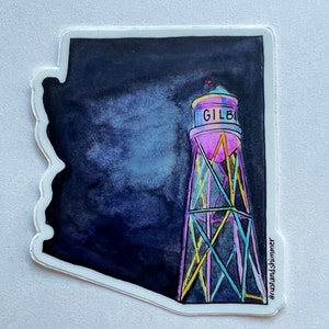 May include: A sticker of a water tower with the word "GILBERT" on it, against a dark blue background. The water tower is outlined in pink, yellow, and blue.