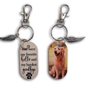 May include: Two keychains with silver-tone hardware and wing charms. One keychain has a photo of a golden retriever. The other keychain has the text "You were my favorite hello and my hardest goodbye" with a paw print.