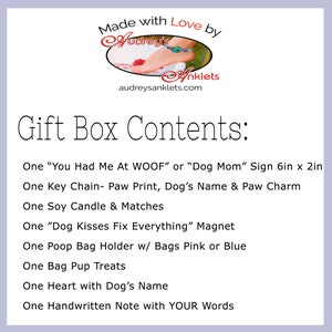 May include: Gift box contents for a dog owner. Includes a "You Had Me At WOOF" or "Dog Mom" sign, a paw print key chain, a soy candle, a "Dog Kisses Fix Everything" magnet, a poop bag holder, dog treats, a heart with the dog's name, and a handwritten note.