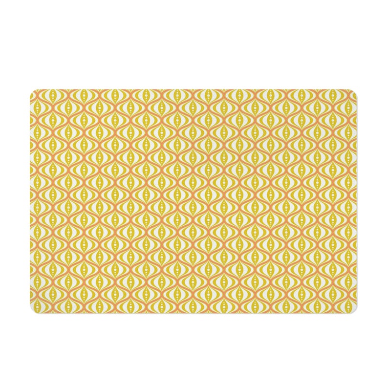May include: A rectangular mat with a repeating retro pattern. The design features a series of interconnected, eye-shaped motifs in shades of yellow, orange, and white. The overall aesthetic is reminiscent of mid-century modern design.