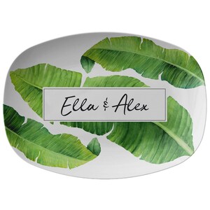 May include: White oval serving platter with a green banana leaf pattern and the text "Ella & Alex" in black.