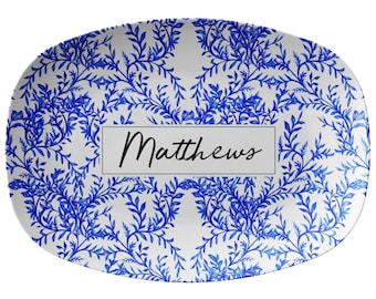 May include: White oval serving platter with a blue and white floral pattern. The platter has the name "Matthews" printed in black on a white rectangle in the center.