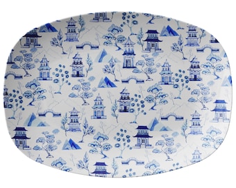 May include: A white oval serving platter with a blue and white pattern of pagodas, trees, and bridges.