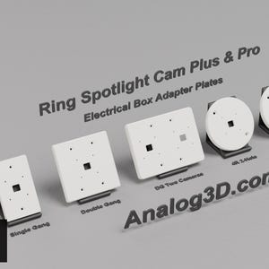 May include: A collection of white Ring Spotlight Cam Plus & Pro electrical box adapter plates. The set includes Single Gang, Double Gang, DG Two Cameras, 4R 2-hole, and 4R 4-hole variants, each mounted on a black stand with text labels.