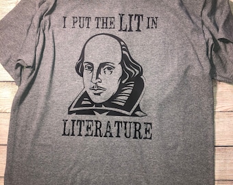 May include: A gray t-shirt with a black graphic of William Shakespeare and the text "I put the LIT in LITERATURE".