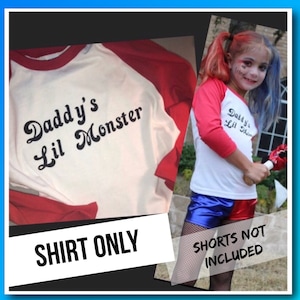 May include: White and red baseball style shirt with the text "Daddy's Lil Monster" in black.  The shirt is for a child.