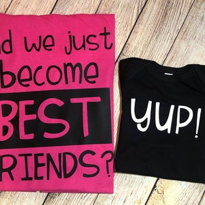 Peut inclure: Deux t-shirts, un rose et un noir, avec le texte "Did we just become BEST FRIENDS?" sur le t-shirt rose et "yup!" sur le t-shirt noir.
