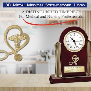 May include: A gold-tone 3D medical stethoscope logo with a heart and wings is attached to a mahogany clock with a gold-tone face and hands. The clock has a plaque with the text "Jennifer D. Smith, RN Registered Nurse Congratulations on Your Graduation Engraved Desk Clock by Awards.com".
