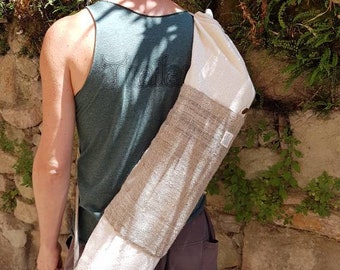May include: A person wearing a green tank top with the word "Thailand" printed on the back, carrying a beige yoga mat strap over their shoulder.