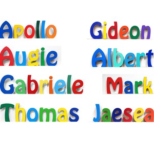 Op de afbeelding: Kleurrijke houten letters die de namen Apollo, Augie, Gabrielle, Thomas, Gideon, Albert, Mark en Jaesea spellen.