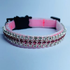 May include: Pink pet collar with two rows of rhinestones, one row of clear rhinestones and one row of pink rhinestones.