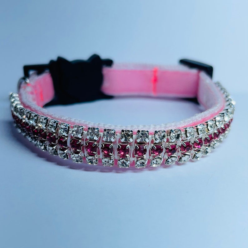 May include: Pink pet collar with two rows of rhinestones, one row of clear rhinestones and one row of pink rhinestones.