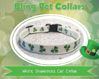 May include: White cat collar with green shamrock print. The collar is adjustable and has a buckle closure.  "Bling Pet Collars" and "White Shamrocks Cat Collar" are written on the image.