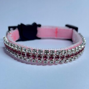 May include: Pink cat collar with a double row of rhinestones, one row of clear rhinestones and one row of pink rhinestones.