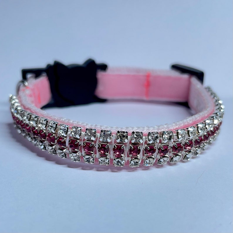 May include: Pink cat collar with a double row of rhinestones, one row of clear rhinestones and one row of pink rhinestones.