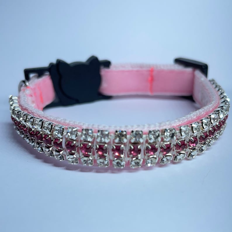 May include: Pink velvet cat collar with a double row of rhinestones, including clear and pink stones.
