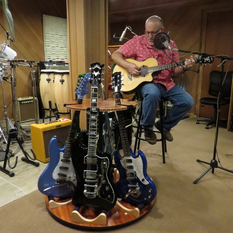 The Carousel Wood Rotating Multi Guitar Stand Holds Acoustics