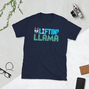 May include: Navy blue t-shirt with a white llama wearing sunglasses and holding a dumbbell. The text "Liftin' Llama" is printed in blue on the shirt.