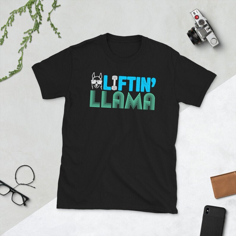 May include: Black t-shirt with a blue and white graphic of a llama wearing sunglasses and lifting a dumbbell. The text "Liftin' Llama" is written below the llama.