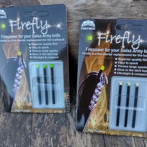 May include: Two identical blister packs of Tortoise Firefly fire starter replacements for Swiss Army knives. Each black card features the text Firefly, Firepower for your Swiss Army knife, and lists features including superior quality flint.