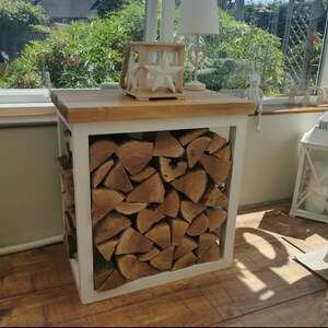May include: White wood log rack with a wooden top. The rack is filled with stacked firewood.