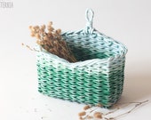 Small green-blue wall hanging storage basket with a loop