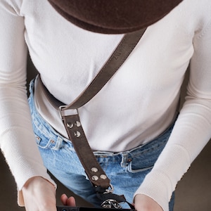 Handmade Dark Brown "Crazy Horse" leather camera strap by Zuka Straps. Cross-body design for comfort, evenly distributing camera weight. Ideal for all-day use in weddings, travel, and wildlife photography. Customizable with hot stamping or engraving.