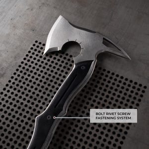 Puede incluir: Un hacha plateada y negra con una hoja curva y un extremo puntiagudo. El mango es negro con un agarre texturizado. El texto "BOLT RIVET SCREW FASTENING SYSTEM" es visible.