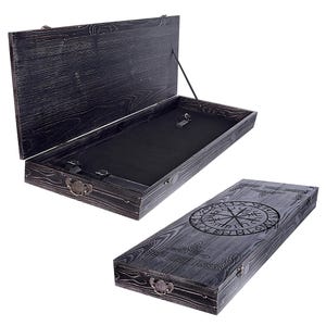 May include: A rectangular wooden storage box with a dark, distressed finish. One view shows the box open, revealing a black felt-lined interior with a small metal latch. The other view shows the closed box with a circular Viking Vegvisir symbol.