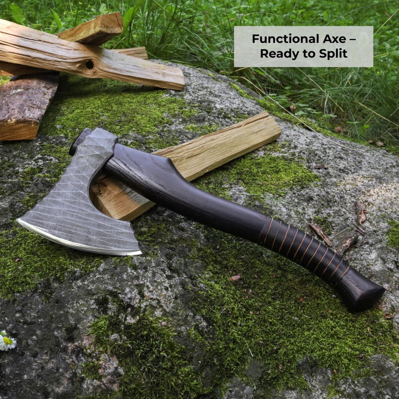 May include: A hand axe with a textured, dark grey metal head and a smooth, dark brown wooden handle wrapped with thin leather cord. The axe head features a curved, sharpened edge. The text "Functional Axe &ndash; Ready to Split" is visible.