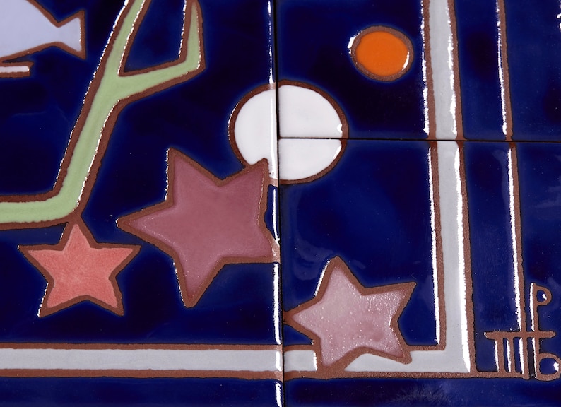 May include: A close-up of a blue ceramic tile with a white, orange, and pink star design. The tile has a white border and a green stem design.