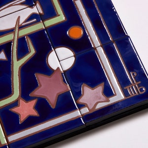 May include: A close-up of a blue and white ceramic tile with a geometric design featuring stars, fish, and a branch. The tile is signed with the initials "LF" in the lower right corner.
