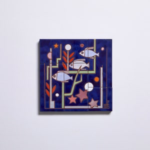 May include: A blue ceramic tile with a geometric design featuring three white fish, red and green plant-like shapes, and white and pink circles. The tile is divided into nine smaller squares.
