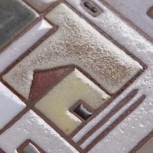 以下が含まれることがあります： 茶色、白、黄色、赤の色合いで幾何学模様が施されたセラミックタイルのクローズアップ。