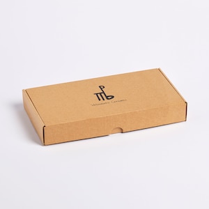 May include: A brown cardboard box with the text "Valimaki Caramels" and a logo of a stylized "MB" printed on the top.