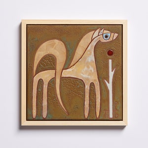 Puede incluir: Un azulejo de cerámica enmarcado con un caballo blanco estilizado sobre un fondo marrón. El caballo tiene un ojo azul y un punto rojo sobre su cabeza. Una rama blanca con un punto rojo se encuentra en el lado derecho del azulejo.