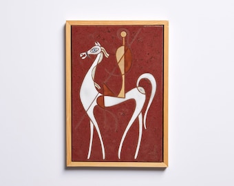 May include: A framed ceramic tile with a white geometric design of a horse and rider on a red background.