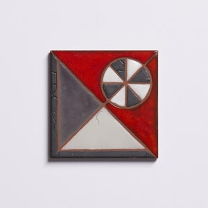 May include: A square ceramic tile with a geometric design. The tile is divided into four sections, each with a different color: red, gray, white, and black. The center of the tile features a black and white circle with a radial design.